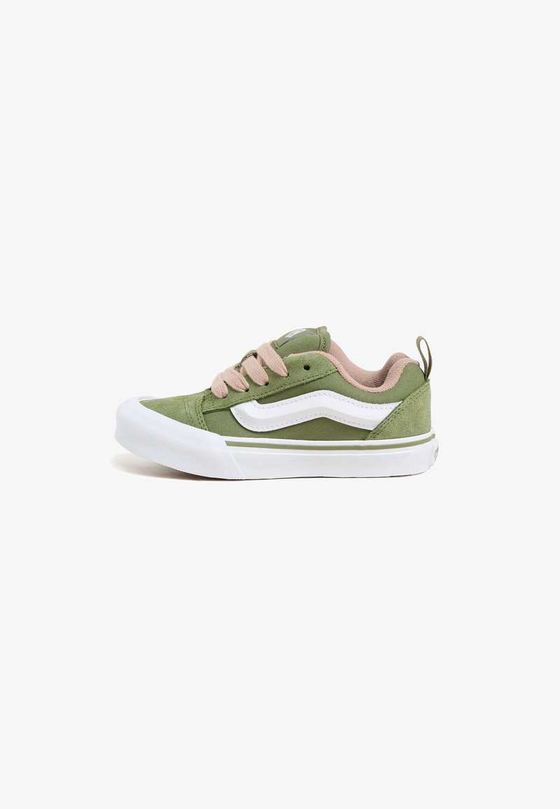 Green canvas sneakers with beige accents, white rubber sole, and lace closure; features side stripe and textured upper.