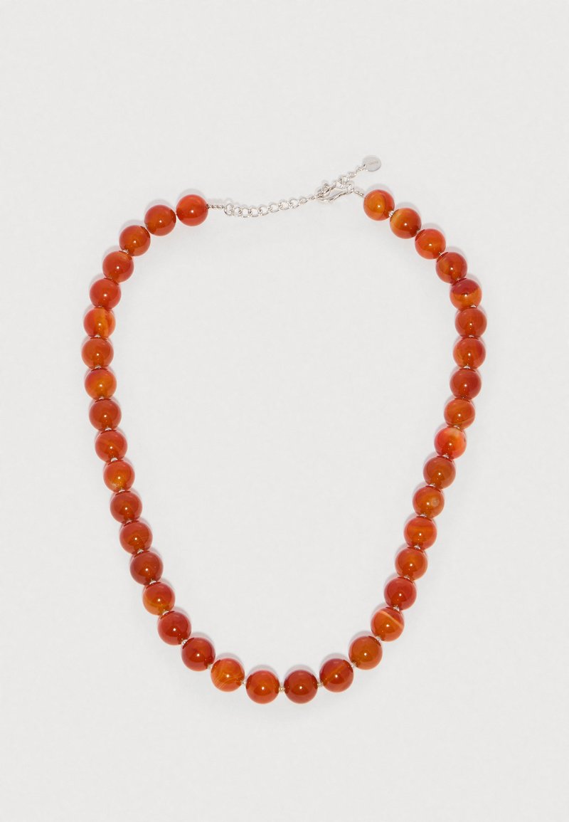 Colier din mărgele rotunde lustruite roșu-portocalii, cu lanț și închizătoare din argint, pe fundal alb.
