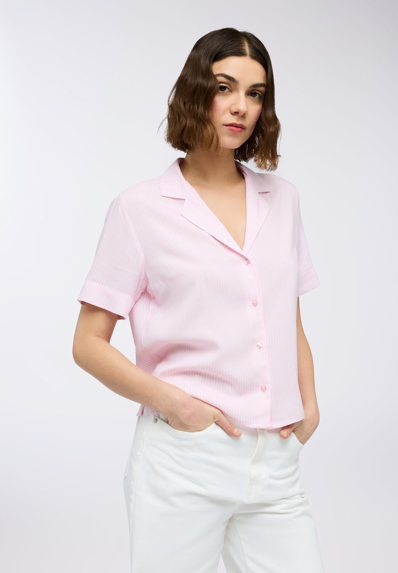 Blusa a maniche corte rosa a righe con scollatura a V e chiusura con bottoni. Il tessuto appare leggero; presenta una vestibilità rilassata e maniche arrotolate.