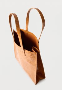 Torba iz umetnega usnja v rjavi barvi s teksturiranim vzorcem krokodila, z dvema dolgima ročajema in odprtim vrhom, ki razkriva neliniran notranjost.