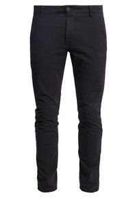 Pantalones negros ajustados de corte slim, fabricados en una mezcla de algodón, con cierre delantero de botón, pasadores para cinturón y una textura suave sin patrones visibles.