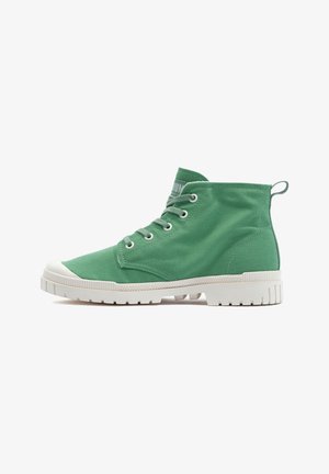 Baskets montantes en toile verte avec semelle en caoutchouc blanche, bout rond et six œillets pour les lacets. Elles sont équipées d'une languette au talon pour un enfilage facile.