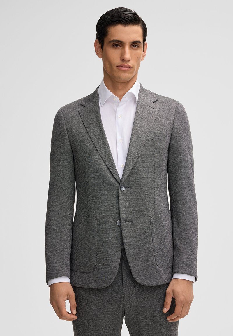 Giacca di suit grigia su misura realizzata in materiale testurizzato, con due tasche frontali e un design a un bottone con due bottoni.