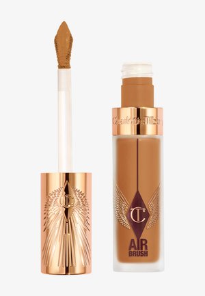 Liquid foundation in a clear glass bottle with rose gold accents. Features a pointed applicator. Shade is a medium brown tone.