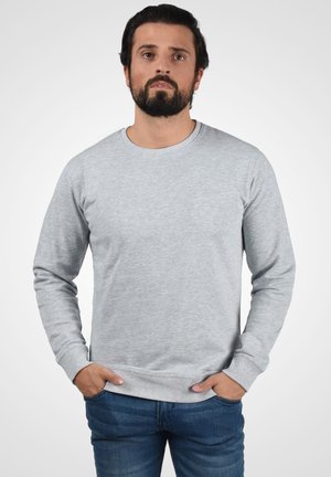 Hall madal hõbe hallist pehmest kangast, millel on ümar kaelus, pikad varrukad, soonikkoes mansetid ja äär, ning juhuslik lõige.