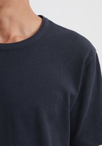 Marineblå bomulds T-shirt med rund halsudskæring og korte ærmer. Glat tekstur og enkelt design, der fokuserer på komfort og pasform.