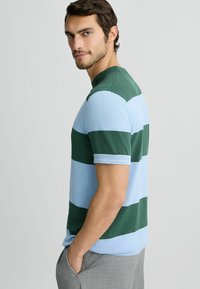 Gestreiftes T-Shirt in Grün und Hellblau mit kurzen Ärmeln, aus einem weichen Stoff gefertigt, mit einem gerippten Rundhalsausschnitt und schlanker Passform.