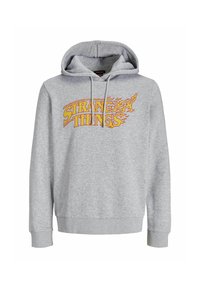 Hoodie gris en mélange de coton avec un graphique avant portant l'inscription "STRANGE THINGS" dans un design de flammes jaunes et oranges. Capuche ajustable et poignets côtelés.