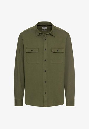 Chemise à manches longues olive en tissu texturé, avec une fermeture à boutons sur le devant, deux poches poitrine et des boutons noirs.