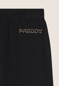 Pantaloni jogger neri in cotone con elastico in vita e la scritta "FREDDY" in strass dorati sul lato. Texture liscia.