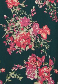 Um tecido floral apresenta flores vibrantes em tons de rosa e vermelho contra um fundo verde escuro, com padrões intrincados de folhas e borboletas dispersas.
