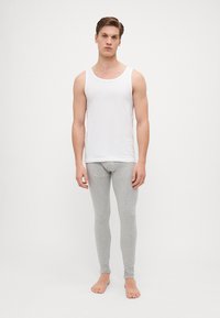 Valkoinen puuvillainen toppi ja vaaleanharmaat slim-fit legginsit. Topissa on pyöreä kaula-aukko ja legginsit ovat sileät ja joustavat.
