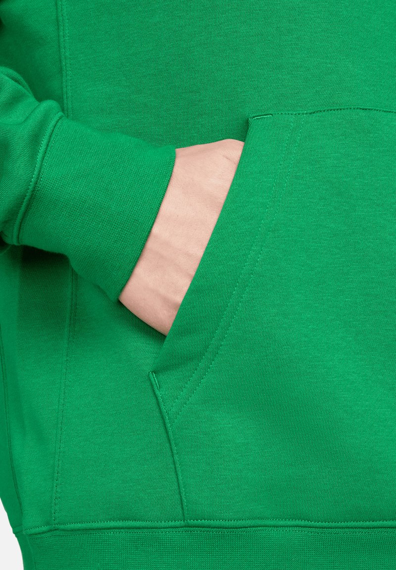 Grüne Sweatshirt mit einer Seitentasche, gerippten Bündchen und weichem Baumwollstoff, der eine einheitliche Textur und lebendige Farbe zeigt.