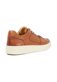 Tan leather sneaker featuring a rounded toe, padded collar, and cream rubber sole, with flat brown laces and subtle stitching details.