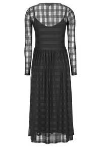 Czarna sukienka z długim rękawem, dopasowaną górą i rozszerzanym dołem, o kratkowanym wzorze na całej powierzchni oraz z dekoltem w serek z tyłu.
