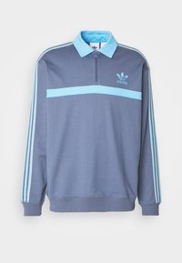 Modrá polyesterová mikina s polovičním zipem u krku, s světle modrými detaily a třemi pruhy podél rukávů. Logo Adidas na hrudi.