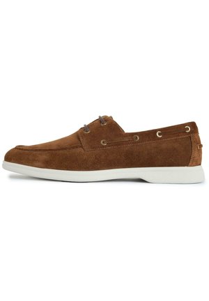 Brown suede casual boat shoe with white rubber sole, lace eyelets, and moc toe stitching, shown in right side profile.