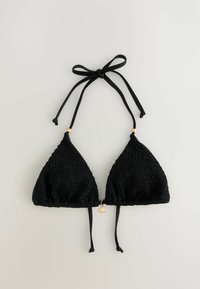 Svart triangelformad bikiniöverdel med smockad textur, justerbara band och guldfärgade detaljer i mitten och vid ändarna av banden.