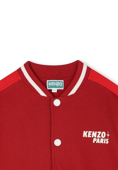 Veste varsity rouge en coton avec col côtelé et rayures blanches. Présente le logo "KENZO PARIS" en blanc. Fermeture à boutons-pression à l'avant.