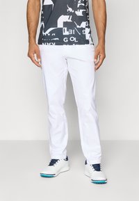 Hvite golfbukser i slim fit, laget av lett stoff. Kombinert med en grå grafisk T-skjorte med fet hvit tekst og former.