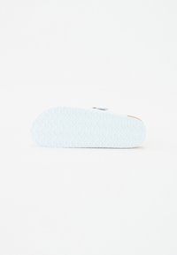 Talpa de pantof albastru deschis cu un model texturat în valuri și un accent bej. Marginea are o ușoară curbă pentru un design aerodinamic.