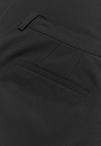 Pantaloni in tessuto nero caratterizzati da un design elegante con una tasca posteriore nascosta e una texture liscia. Il tessuto appare resistente e versatile.