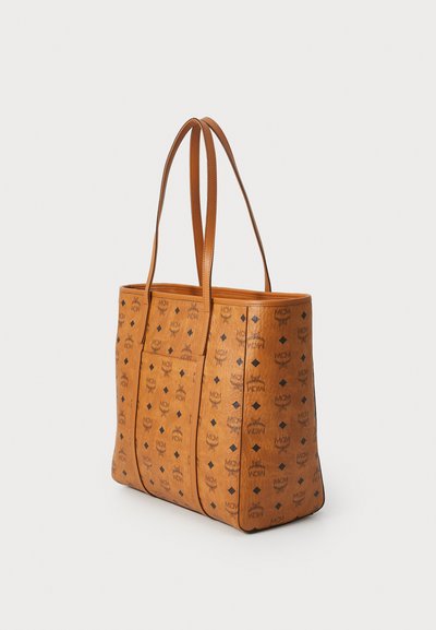 Tan tote bag made of coated canvas, featuring a logo pattern in dark brown. Two long handles, structured shape, and open top design.