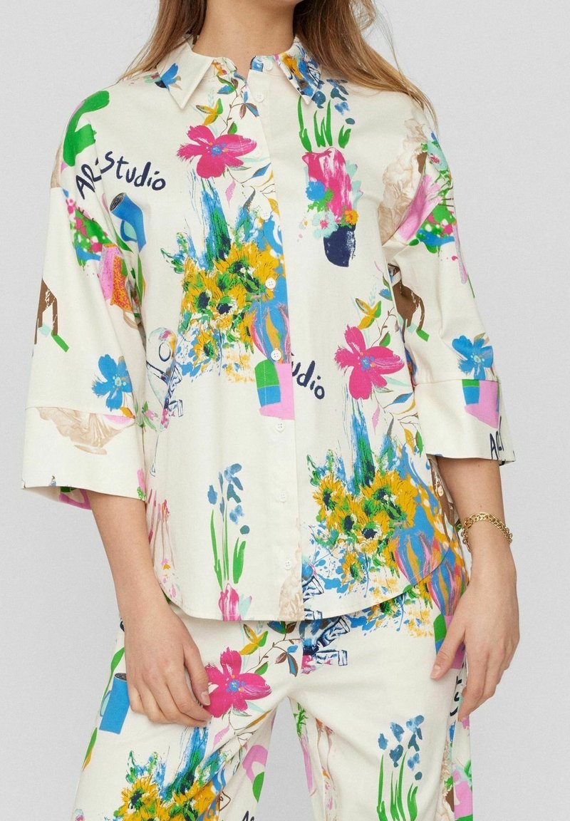 Overhemd met knopen gemaakt van lichte stof, met een kleurrijk bloemen- en abstract patroon, met driekwart mouwen en een kraag.