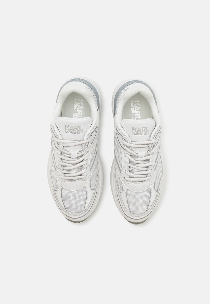 Baskets blanches avec une tige en mailles et en cuir, bout rond, design à lacets et branding subtil sur la languette et sur le côté.