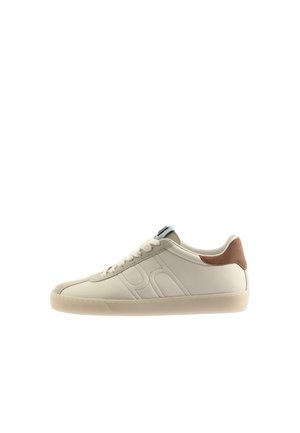 Low-top beige sneaker with suede brown heel tab, stitched side logo, lace-up closure, and a translucent rubber sole.