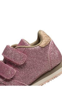 Rosa glittriga sneakers med två kardborreband, en texturerad beige accent vid hälen och en gummisula i ljusrosa färg.