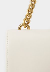 Δερμάτινη τσάντα σε κρεμ απόχρωση με χαρακτηριστική χρυσή αλυσίδα, διαθέτοντας το λογότυπο 'PINKO' σε μεταλλική λεπτομέρεια. Απαλή υφή, μινιμαλιστικός σχεδιασμός.
