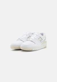 Sneakers bianchi con tomaia in pelle liscia, lacci, collo imbottito e suola in gomma beige. Presentano un logo decorativo laterale e dettagli di cucitura.