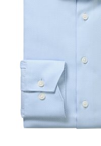 Light blue textured dress shirt with double-button angled cuff and white buttons along the front placket.