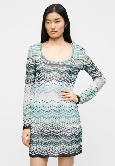 Πλεκτό φόρεμα με μακριά μανίκια, με ζιγκ-ζαγκ μοτίβο σε αποχρώσεις aqua, γκρι και μαύρο. Τετράγωνο ντεκολτέ και εφαρμοστή σιλουέτα.