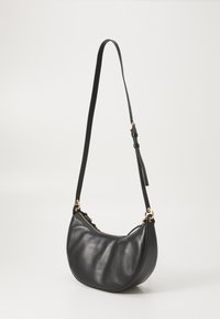 Borsa a spalla in pelle nera con forma curvata, texture liscia e hardware in tono oro; presenta una lunga tracolla regolabile e una chiusura con zip.