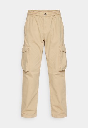 Beige cargobroek gemaakt van katoen, met een elastische tailleband, voorzakken en twee zijvakjes met kleppen.
