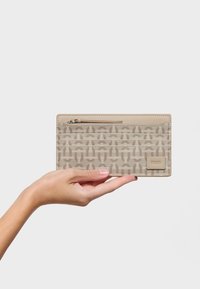 Portafoglio beige con superficie decorata, dotato di più scomparti per carte, un comparto con cerniera e una linguetta con il marchio su un lato.
