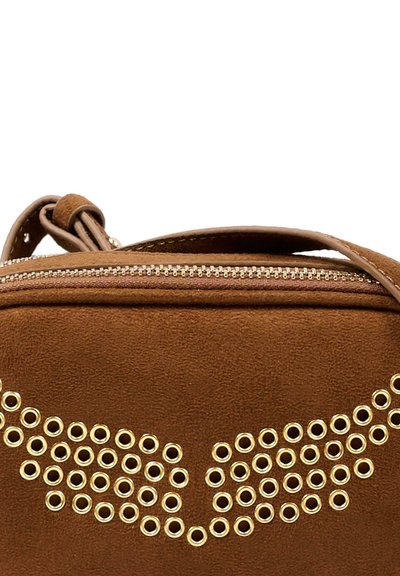 Bruine suèleren handtas met gouden metalen oogjes, gerangschikt in een vleugelachtig patroon onder een bovenste rits en handvat.
