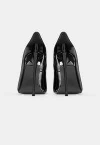 Black patent leather high heels with a pointed toe and slim stiletto heel. Smooth, shiny surface with minimal detailing.
