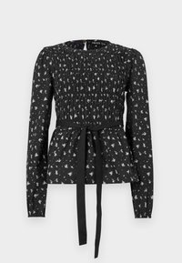 Blouse noire à manches longues avec un corsage smocké, une ceinture à nouer et un motif floral blanc sur toute la surface. Tissu doux avec une silhouette à basque.