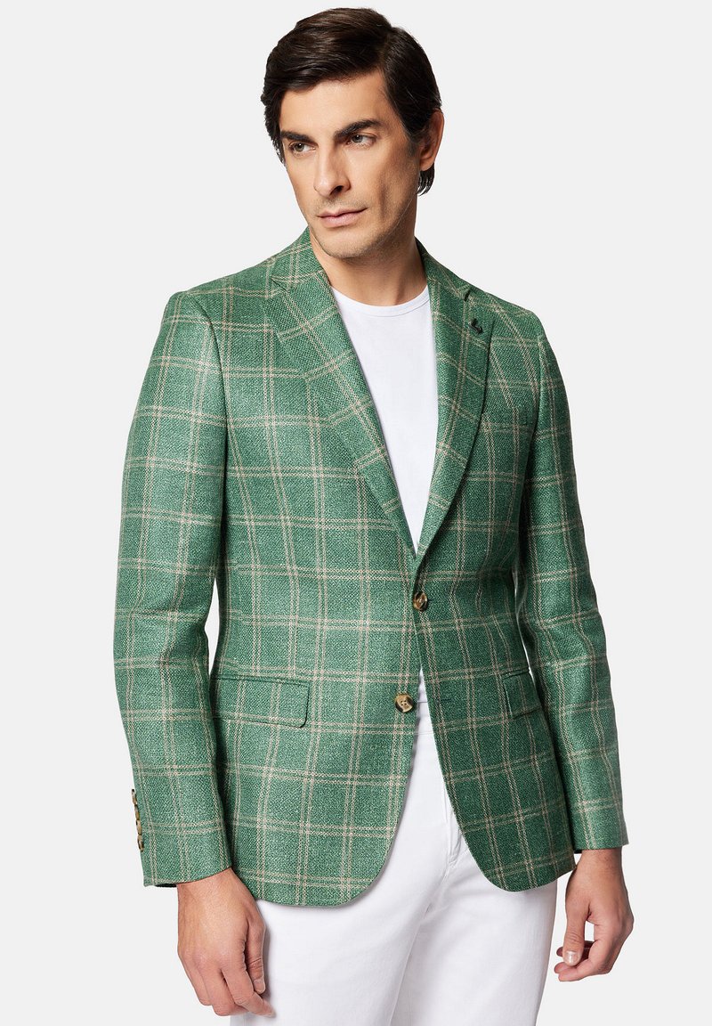 Zielona marynarka w kratę z teksturowanej tkaniny, z zapięciem na dwa guziki, klapami i kieszenią na piersi z brązowymi akcentami guzika.