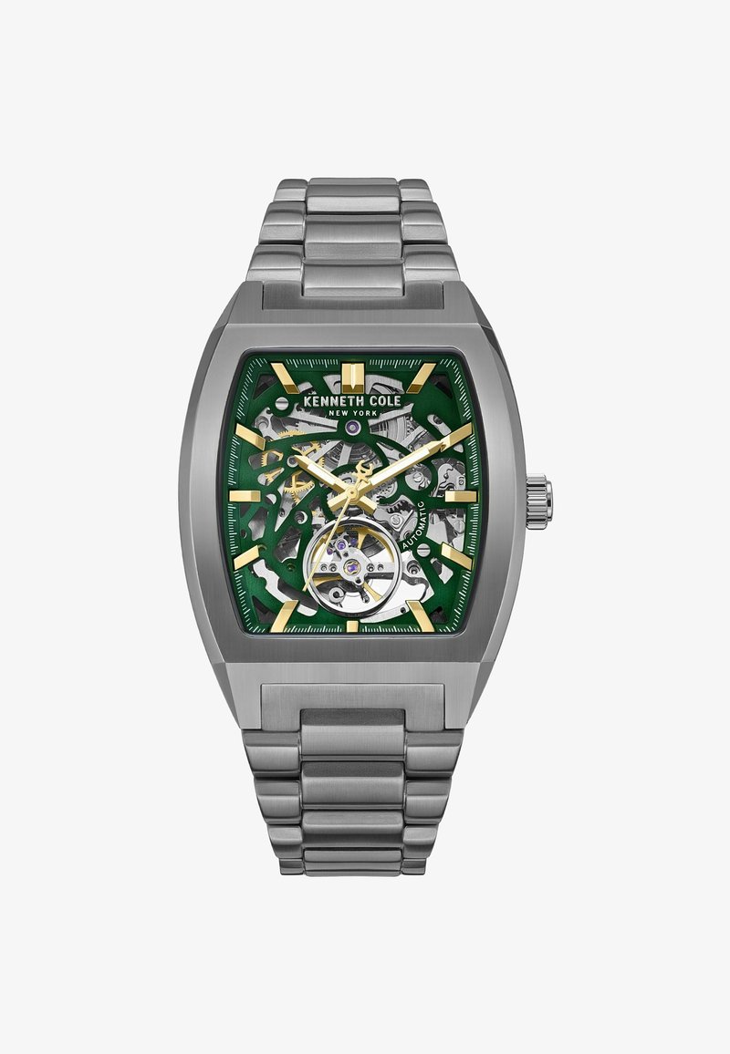 Prostokątny męski zegarek z srebrną stalową bransoletą, zieloną tarczą typu skeleton, złotymi akcentami oraz odsłoniętym automatycznym mechanizmem.