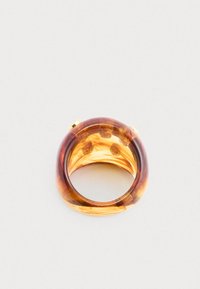 Μια διαφανής ρητίνη χρώματος κεχριμπαριού με σπειροειδή μοτίβα, που διαθέτει στρογγυλεμένο σχήμα και διακριτές χρυσές λεπτομέρειες.