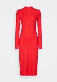 Röd ribbad klänning med långa ärmar, hög hals och en figurnära silhuett. Har subtil branding på sidan. Mjukt, elastiskt tyg.