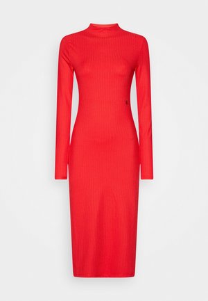 Rode geribde jurk met lange mouwen, hoge halslijn en een getailleerd silhouet. Heeft subtiele merkvermelding op de zijkant. Zacht, rekbaar materiaal.