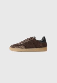 Sneaker in suede marrone con una punta glitterata marrone, lacci marroni e un controcanto nero, montata su una suola in gomma color gomma.