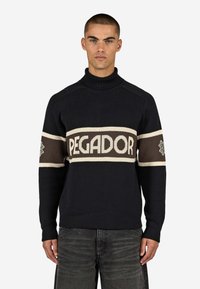 Gestrickter Pullover in dunklem Marineblau mit hohem Kragen, einer cremefarbenen und braunen Streifen mit dem "PEGADOR"-Logo sowie gemusterten Akzenten an den Ärmeln.
