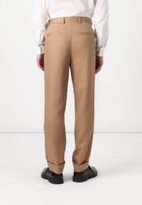 Beige dress pants with a straight cut, featuring two back pockets and a belt loop waist. Fabric appears smooth with a clean finish.