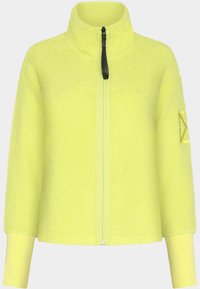 Fleece-takki kirkkaan keltaisena, jossa on korkea kaulus, vetoketjukiinnitys ja ribatut hihansuut. Hihassa on pieni tehostepatch.